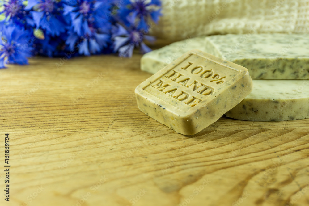 Handmade soap on a rustic wooden board with cornflowers and accessories. Handmade soap on a rustic wooden board with cornflowers and accessories.