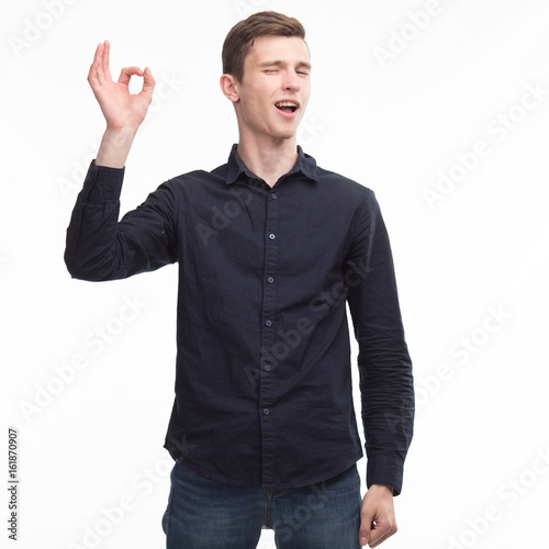 Young happy man showing ok by hand on a gray background. Ideal for banners, registration forms, presentation, landings, presenting concept.