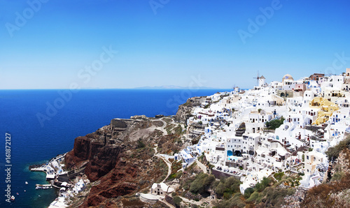 Panoramic view of the village of Oia, Santorini, Greece. Traditional Greek architecture, white houses, the Aegean Sea, the caldera.
