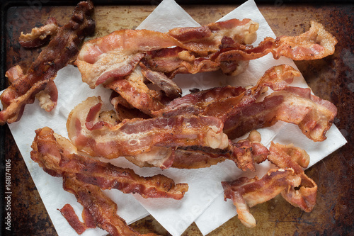 fried baccon stack on white papertowels on baking sheet photo