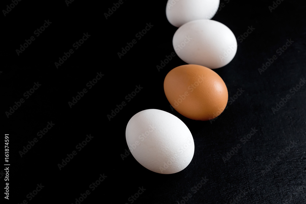 Chicken eggs on black baclground White eggs on black background Vertical photo Eggs background Place for text