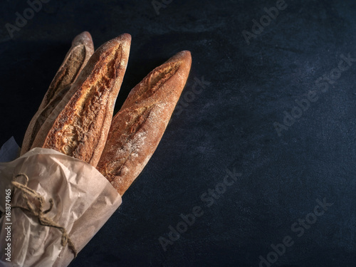Three freshly baked baguettes on the table.