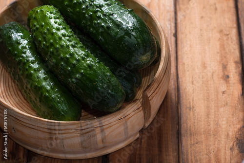 Whole cucumbers in wooden utensils 