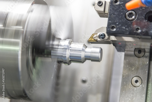CNC lathe machine (Turning machine) cutting the aluminium screw thread shaft.Hi-precision CNC machining concept.