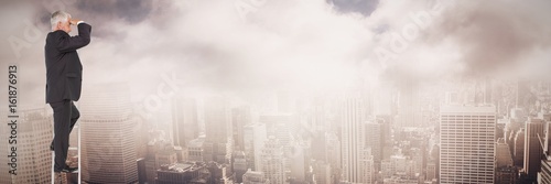 Composite image of mature businessman standing on ladder