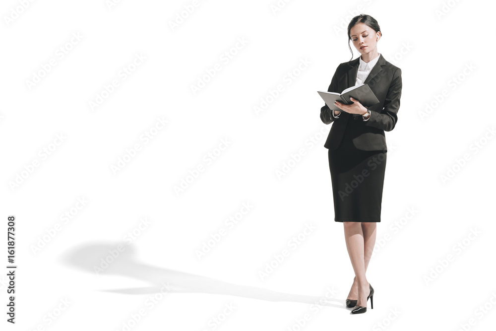 Beautiful businesswoman holding diary and planning her work, isolated on white Beautiful businesswoman holding diary and planning her work, isolated on white