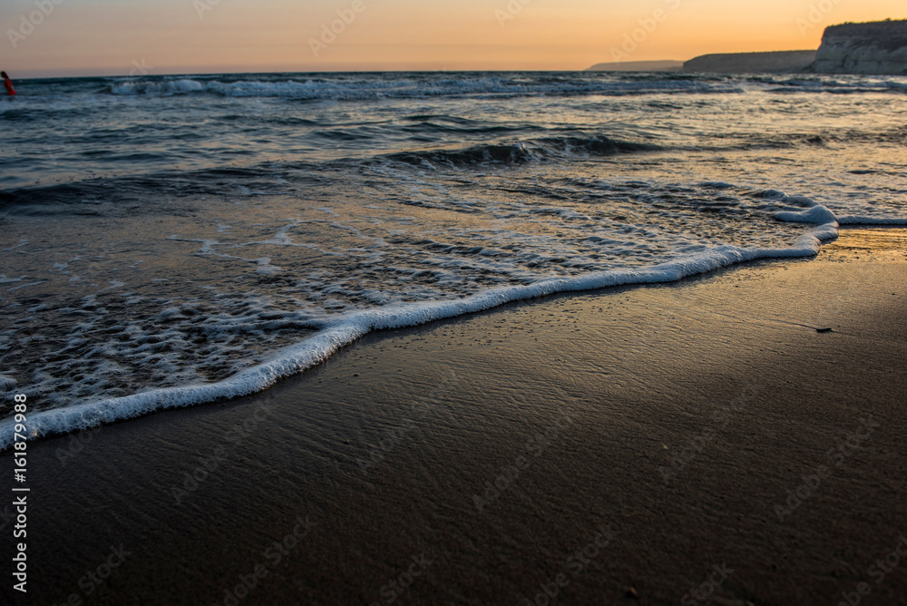 Waves approaching sandy beach during sunset Waves approaching sandy beach during sunset
