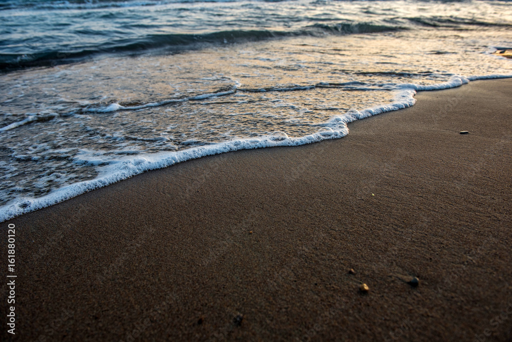 Waves approaching sandy beach during sunset Waves approaching sandy beach during sunset