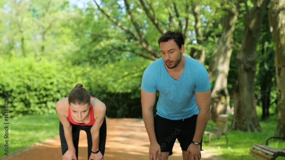 Tired, man and woman catching breath after jogging, running at the park. Exhausted couple after training. close up Tired, man and woman catching breath after jogging, running at the park. Exhausted couple after training. close up