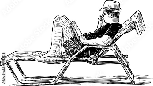 A person reads a book on the beach