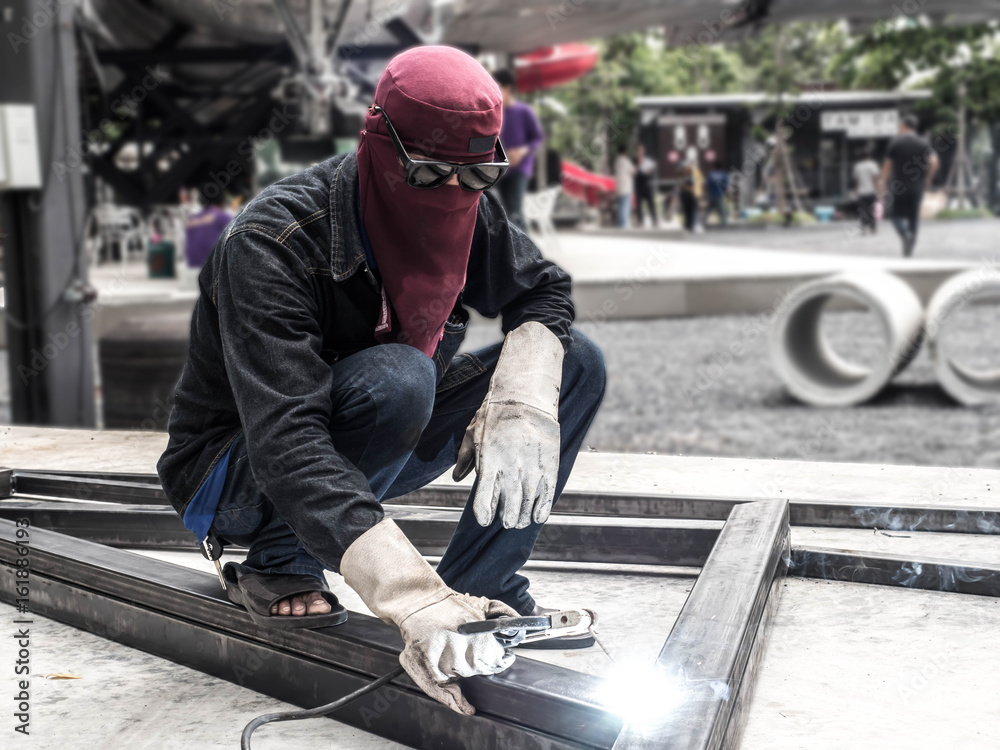 Worker welding parts of stell construction Worker welding parts of stell construction
