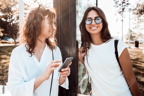 Two women waiting for a bus at a bus stop
