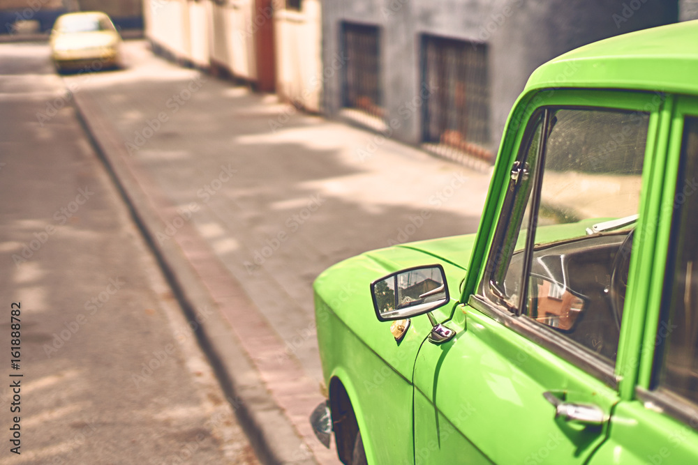 Vintage green car parked on a summer street