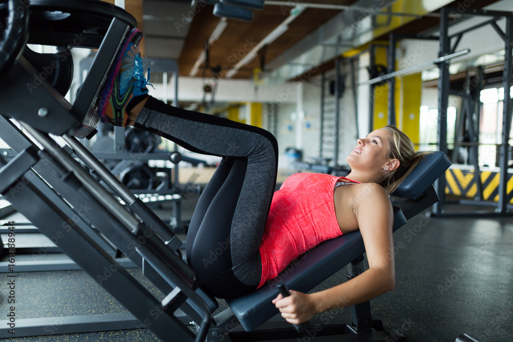 Woman doing exercises in gym for legs Woman doing exercises in gym for legs
