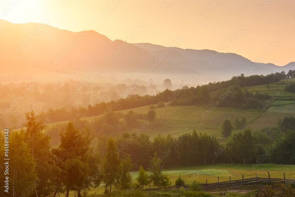 Green mountain hills at sunrise in gentle golden light