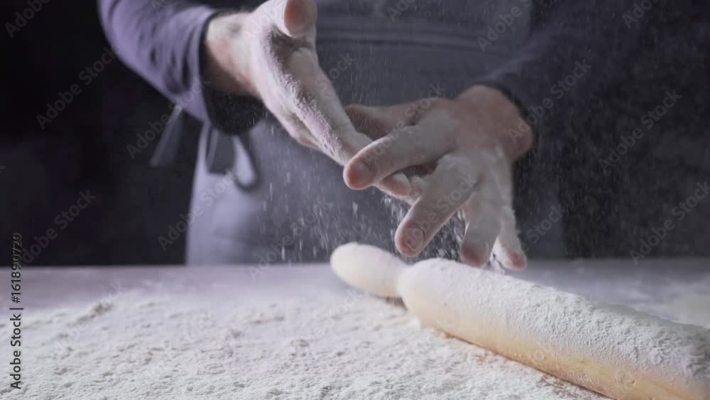 The cook's hands in flour, baker at work, bread and bakery, flour at the kitchen The cook's hands in flour, baker at work, bread and bakery, flour at the kitchen
