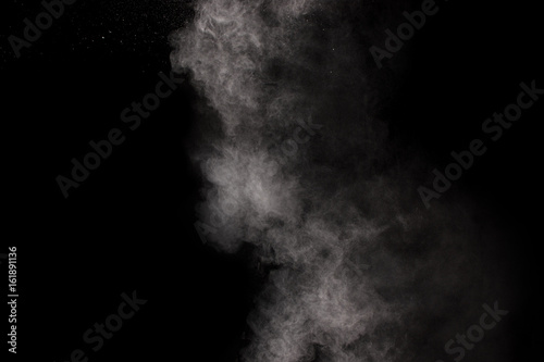 hrowing talcum powder out of hand. Stopping the movement of white powder on dark background.