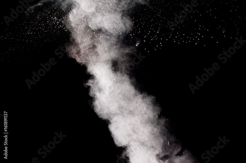 hrowing talcum powder out of hand. Stopping the movement of white powder on dark background.