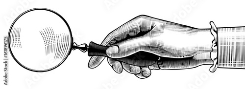 Woman's hand with an old magnifying glass