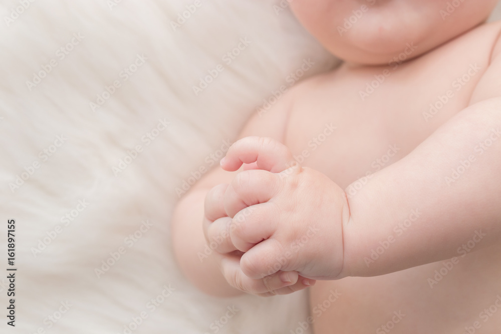 Newborn hands detail closeup. Lying on the bed and folding the hands Newborn hands detail closeup. Lying on the bed and folding the hands