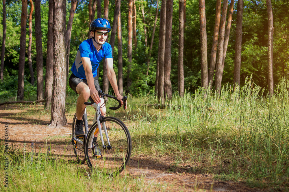 Young bicyclist riding in the forest