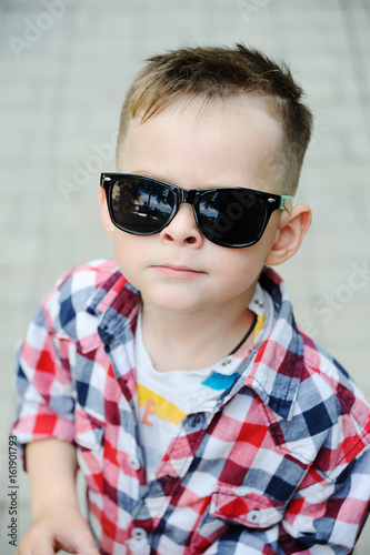 Baby boy in plaid shirt with sunglasses. Children's fashion