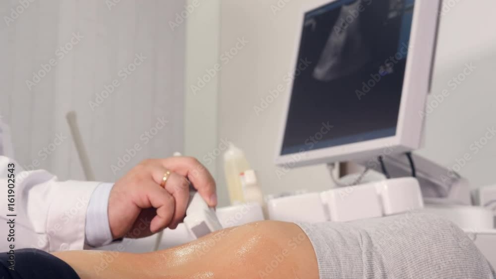 Close up of the doctor making the ultrasound examination of the abdominal cavity Close up of the doctor making the ultrasound examination of the abdominal cavity
