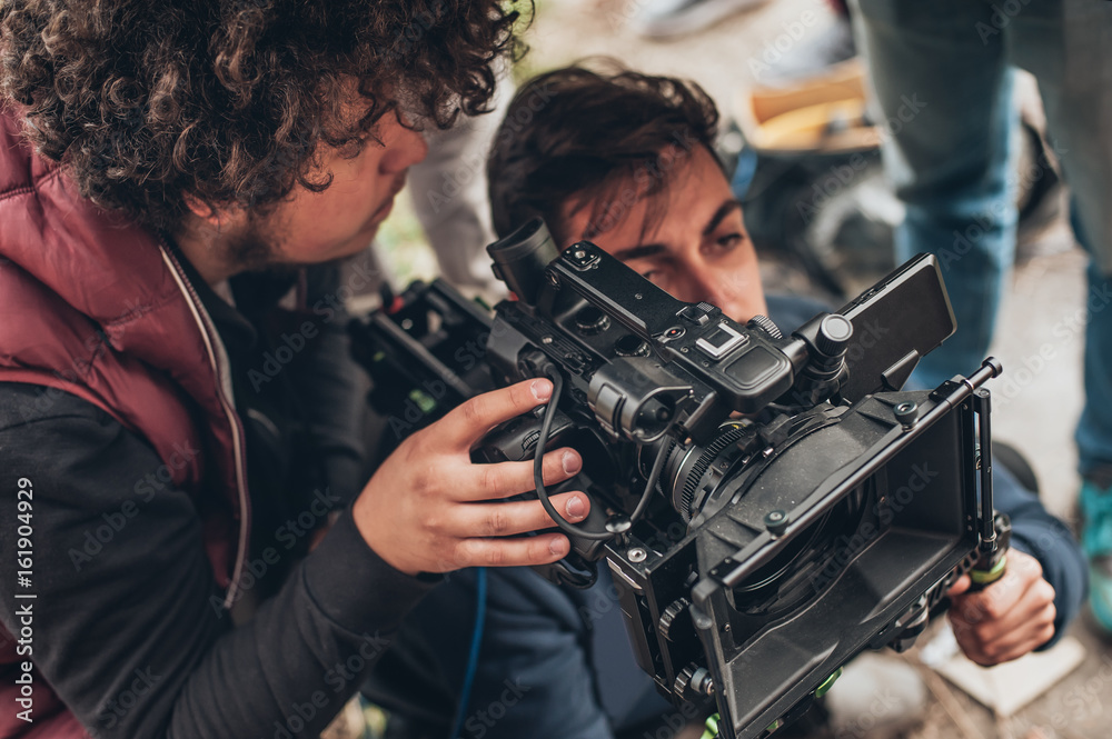 Behind the scene. Cameraman and assistant shooting film with camera Behind the scene. Cameraman and assistant shooting film with camera
