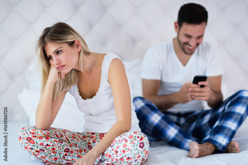 Young couple in bed having problems and crisis Young couple in bed having problems and crisis