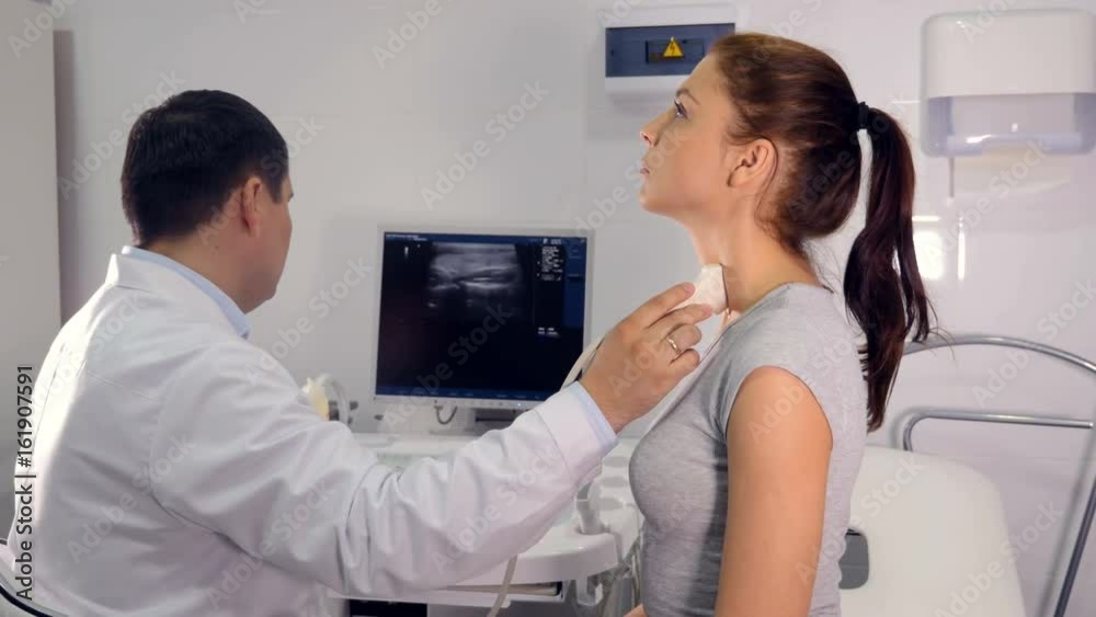 Close up of the doctor making the ultrasound examination of the larynx Close up of the doctor making the ultrasound examination of the larynx