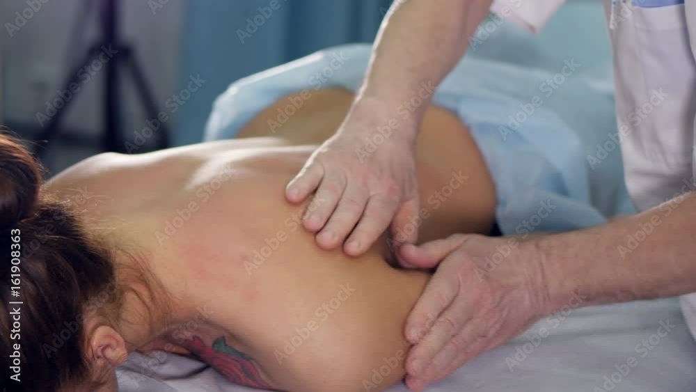 Close up f the massage therapist massaging woman's back