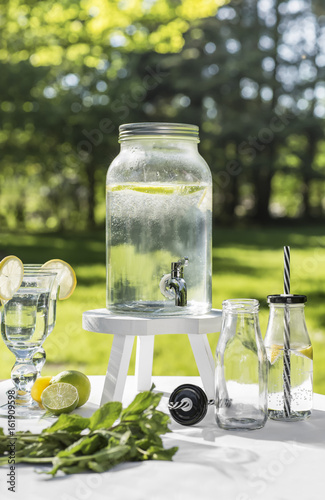 Wasserspender mit Gläsern im Garten photo