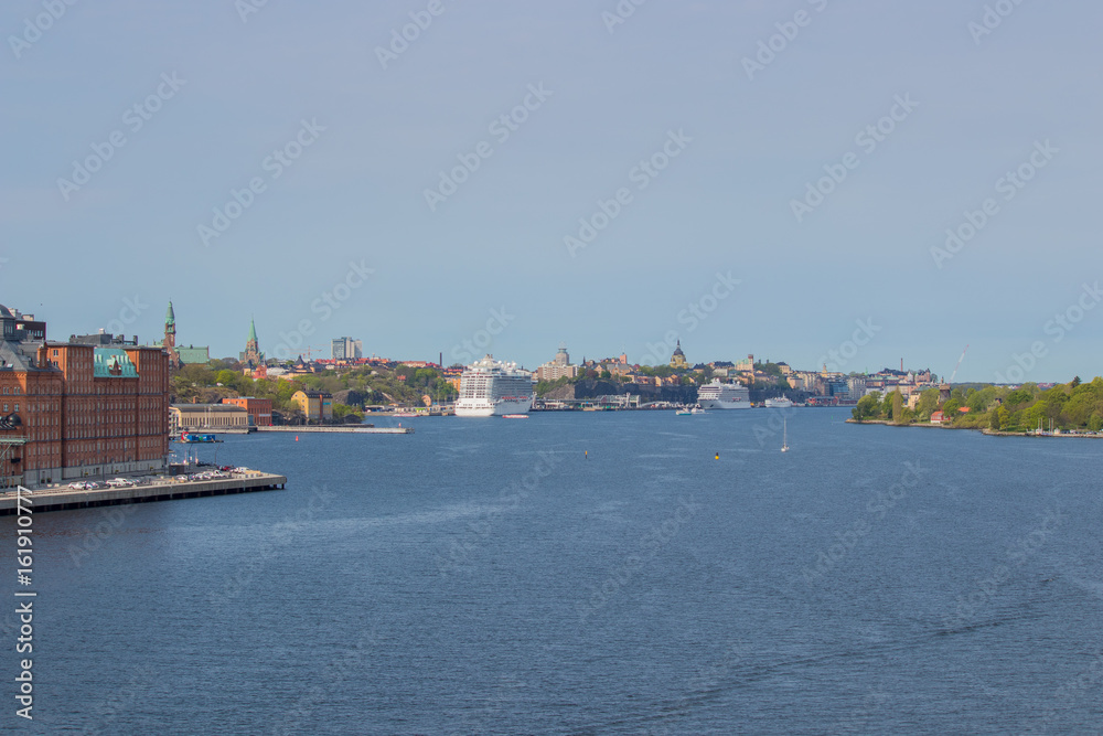 Fototapeta premium Southern Stockholm seen from the fjord in southwestern direction. The cruise ships are docked at Stadsgarden harbour.