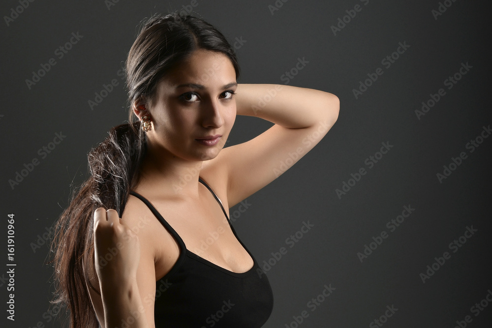 Beautiful woman posing in studio on dark background Beautiful woman posing in studio on dark background