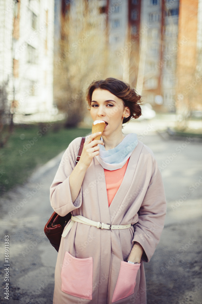 Young woman eating ice cream outdoor in city