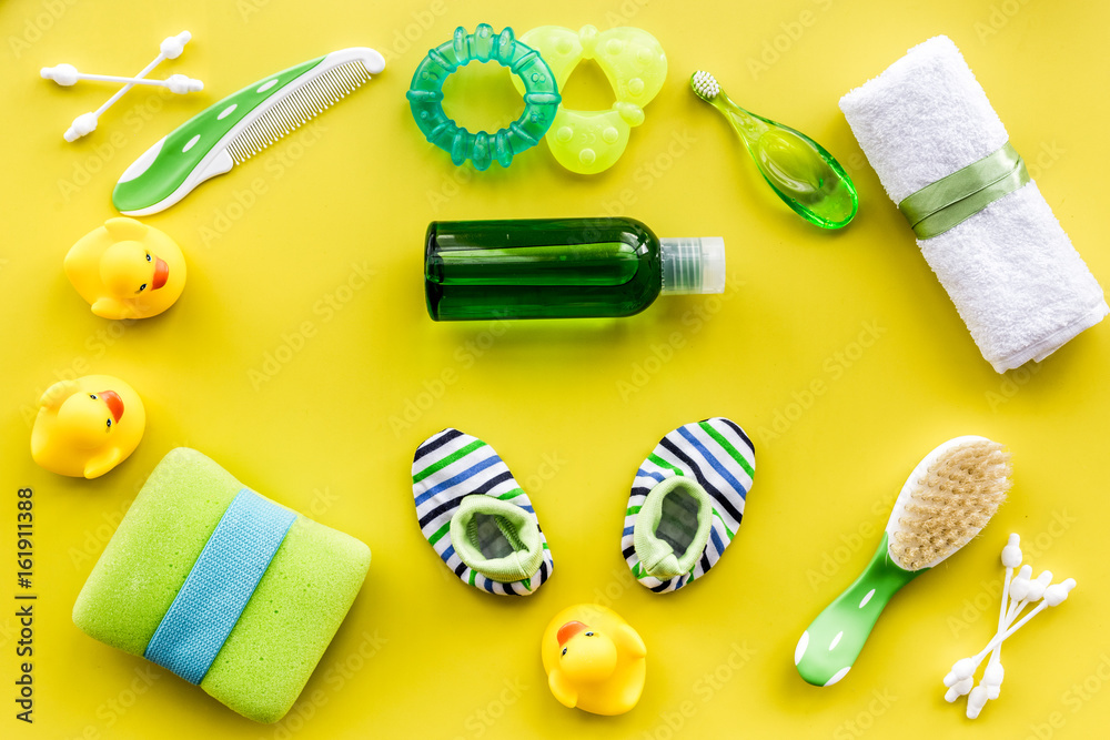 Baby care with bath set, ducklings and towel on yellow background top view pattern