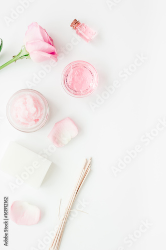 spa set with rose flowers and cosmetic for body on white desk background top view mockup