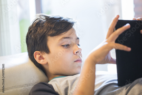 boy playing with his tablet