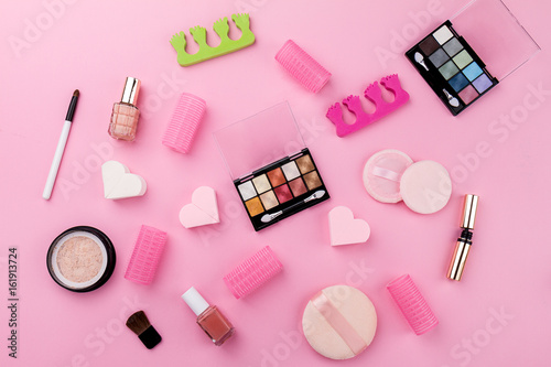 Beauty Spa Feminine Concept. Different Make Up Beauty Care Essentials Cosmetics on Flat Lay Pink Background. Top View. Above.