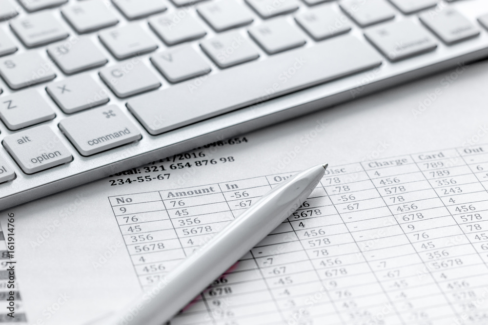 Business report preparing with pen and keyboard on office background Business report preparing with pen and keyboard on office background