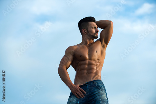 sexy man with muscular body on blue sky