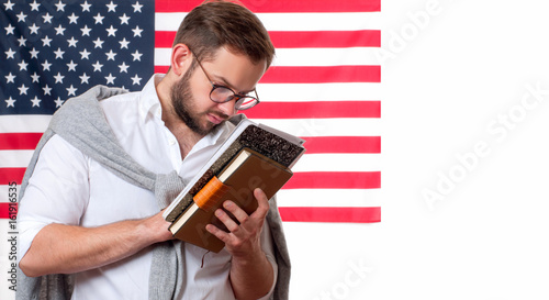 American flag. Smiling young man on United States flag background. photo