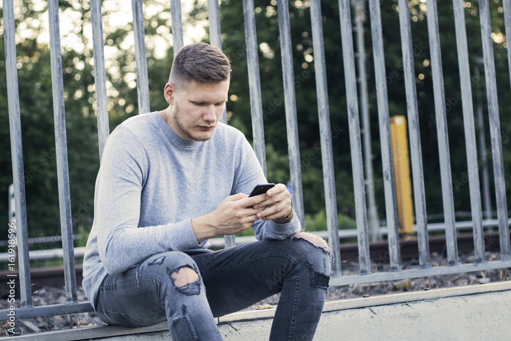 Obraz premium Junger Mann schreibt eine SMS
