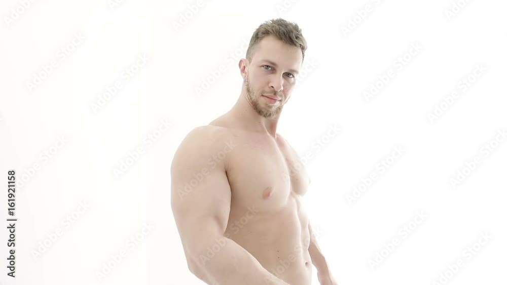 Medium shot of a muscular bodybuilder doing arm exercises with a resistance band on a white background Medium shot of a muscular bodybuilder doing arm exercises with a resistance band on a white background