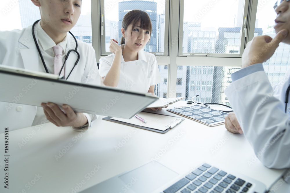 Doctors and nurses are talking while watching medical charts Doctors and nurses are talking while watching medical charts