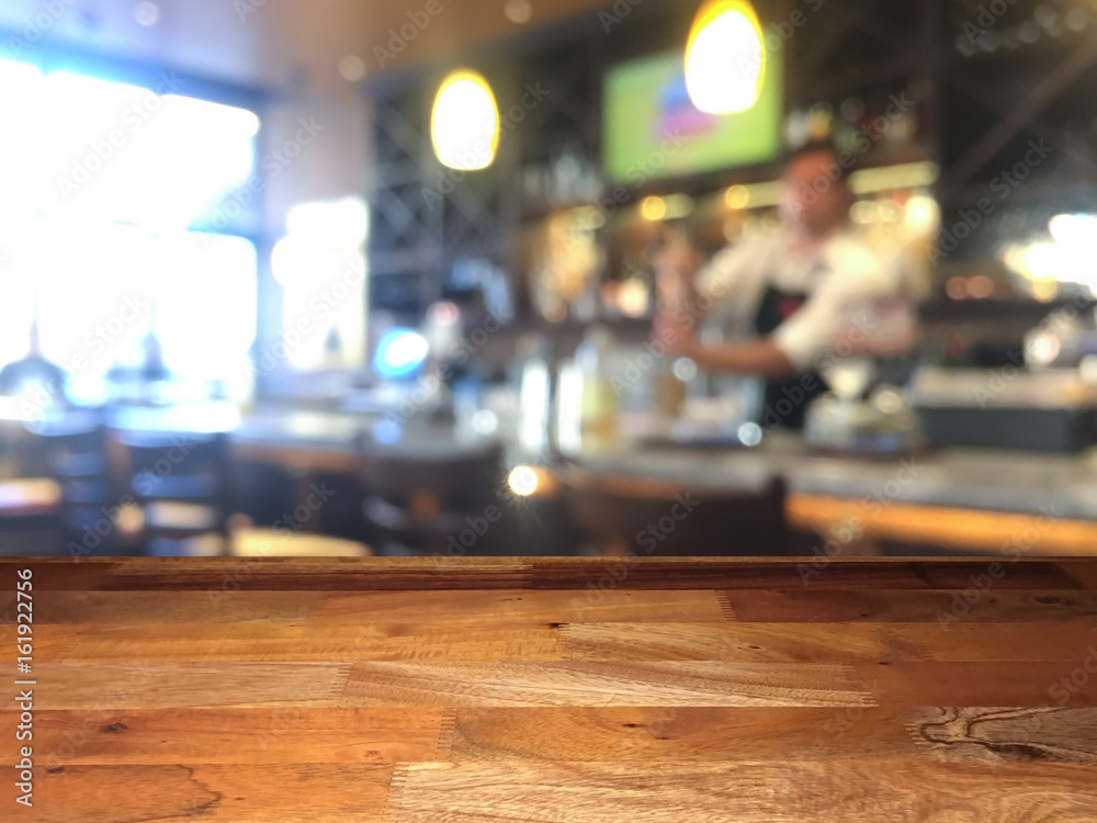Empty wooden table top with blurred bar on background Empty wooden table top with blurred bar on background