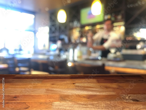 Empty wooden table top with blurred bar on background