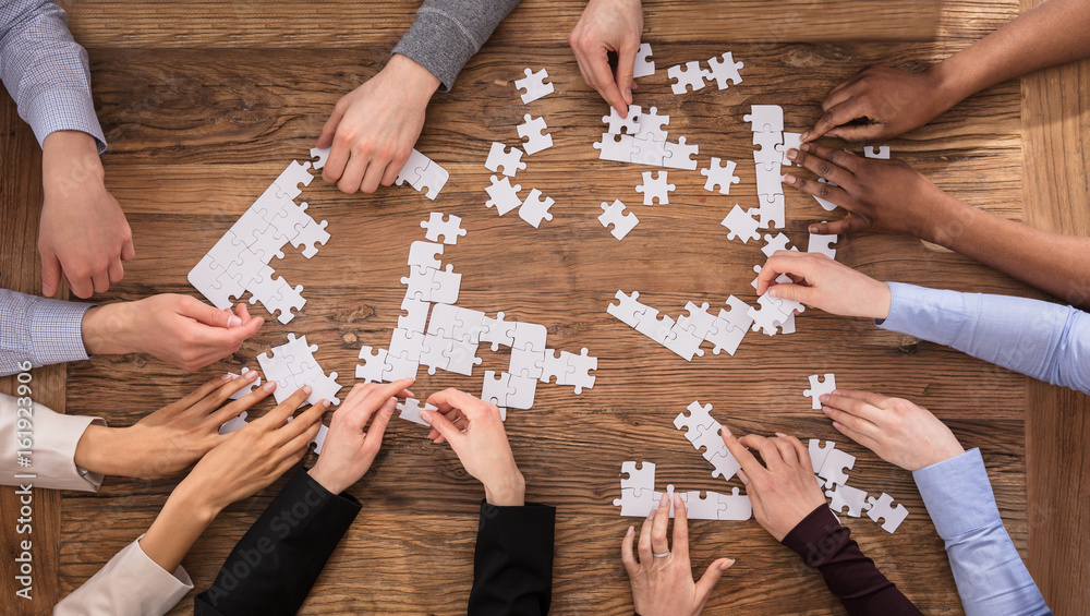 High Angle View Of Businesspeople Solving Jigsaw Puzzle Stock Photo | Adobe  Stock