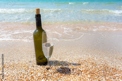 Bottle of wine in sand on the beach