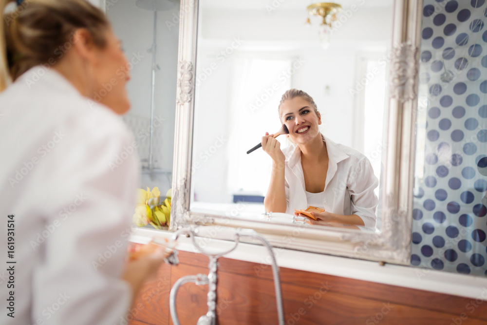 Beautiful girl in bathroom applying makeup Beautiful girl in bathroom applying makeup